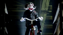 Jigsaw from the movie Saw on a bicycle