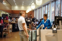 A man receiving a complimentary checked bag in the Lamont Cafe