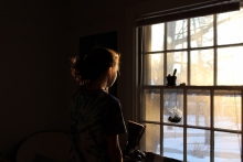 Woman stares longingly out window
